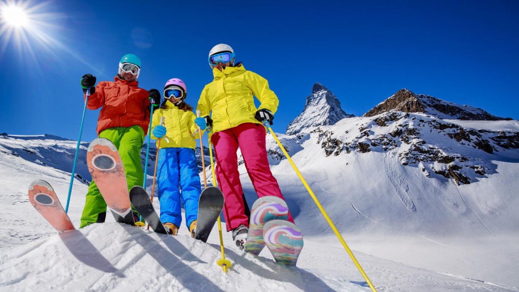 Skiing, winter, snow, sun and fun - family enjoying winter vacations in Zermatt, Switzerland.